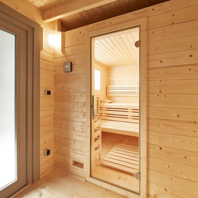 Gartensauna Bella Inneneinrichtung: Bequeme Liegen, komfortable Rückenlehnen, 2 Kopfstützen, formschöne Zwischenbankverkleidung, Ofenschutzgitter, Fußrost, Eckblendschirm mit Saunalampe